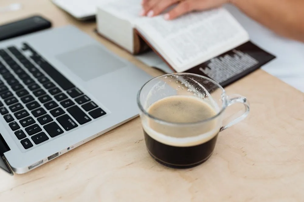 Reading car financing guides with a laptop and coffee