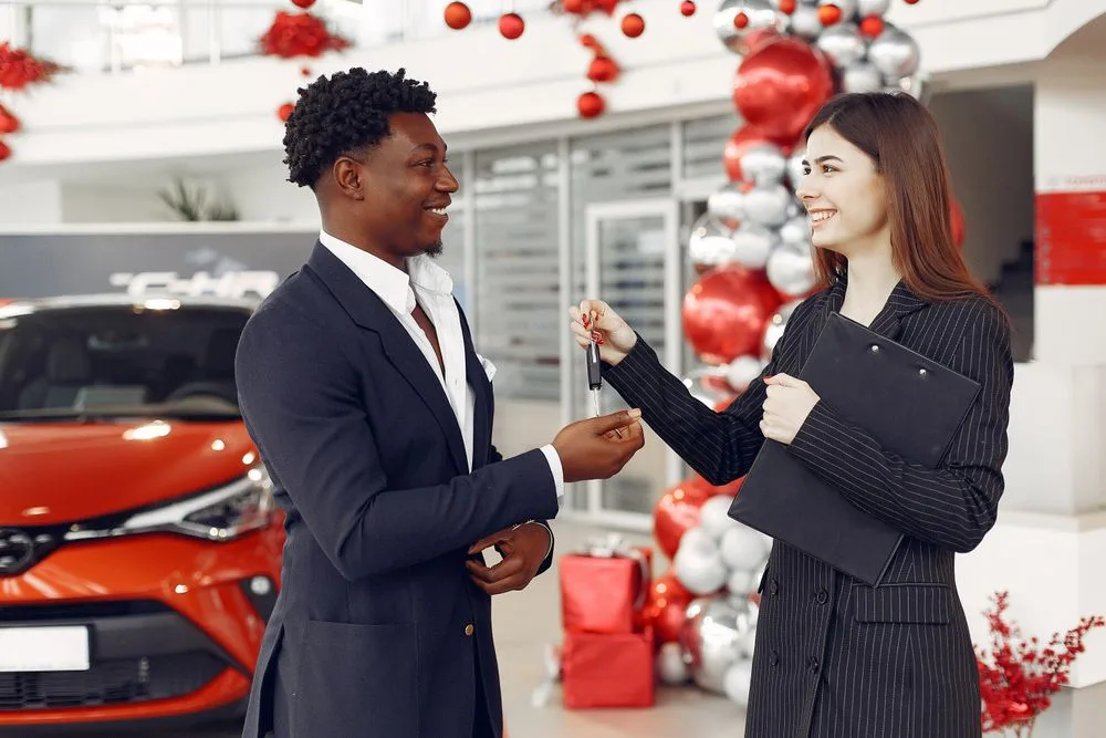 Customer receiving car keys after financing again following a repossession in Saskatchewan