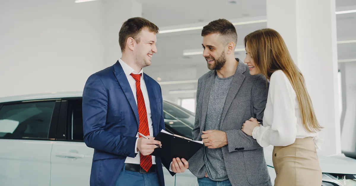 Couple using a car loan calculator with a dealer in Canada