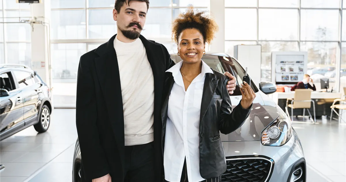 Couple approved for a car loan in Canada holding their new car keys