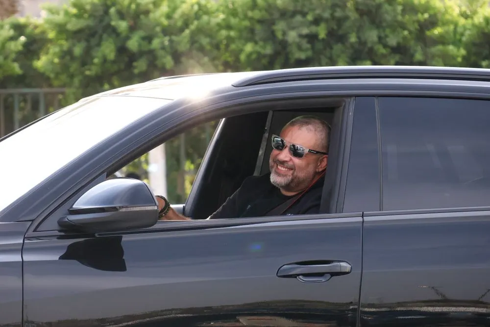 Driver smiling behind the wheel after refinancing his car loan in Canada