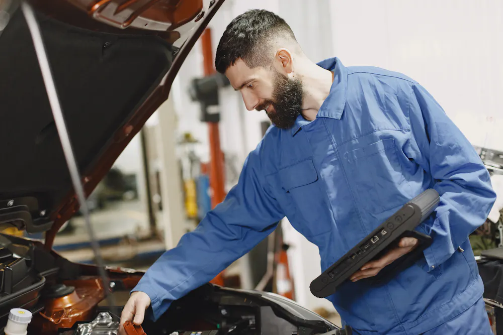 Mechanic inspecting a used car before financing in Canada