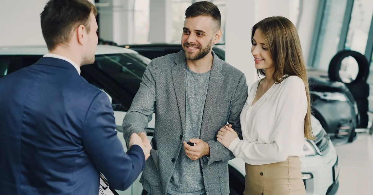 Car loan cosigner discussion at a Canadian dealership with a couple and salesman