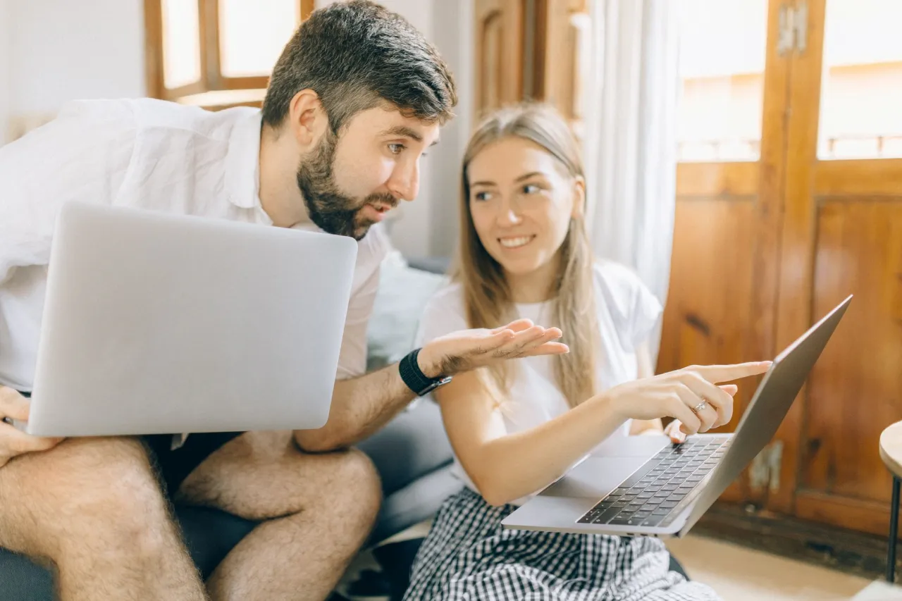 Couple comparing lease or finance numbers at home