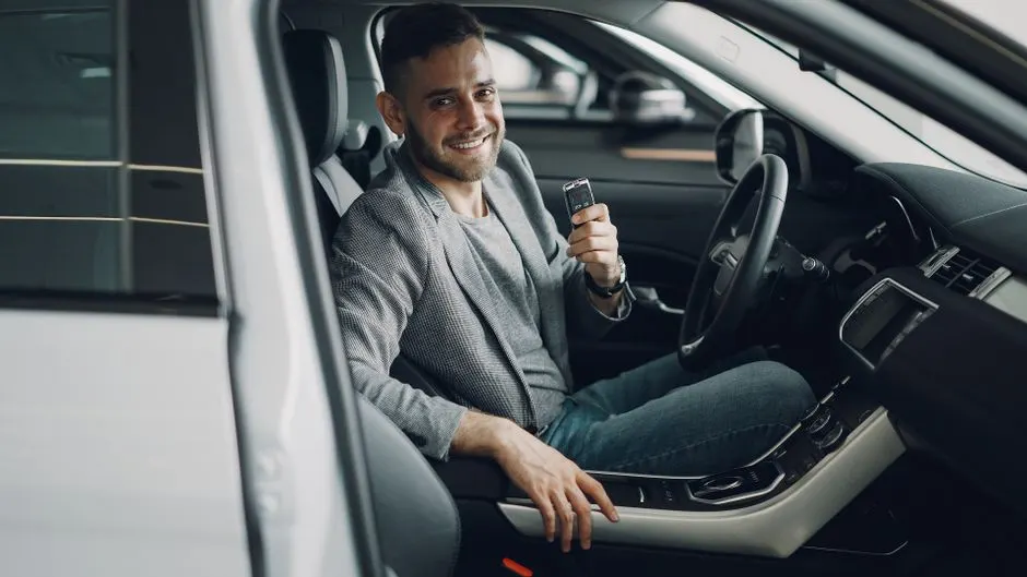 Pre-approved buyer holding the keys inside his new vehicle