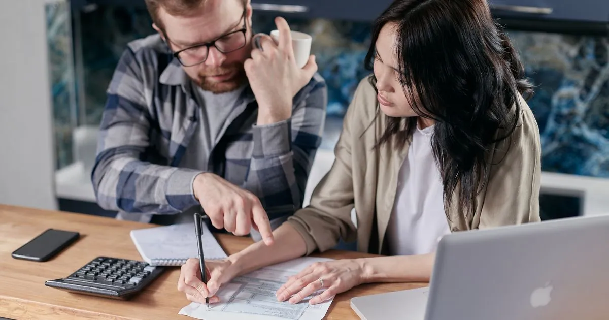 Reviewing refinance auto loan paperwork and payments at home in Canada