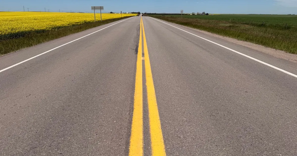 Car loans Manitoba: an open prairie highway between canola fields