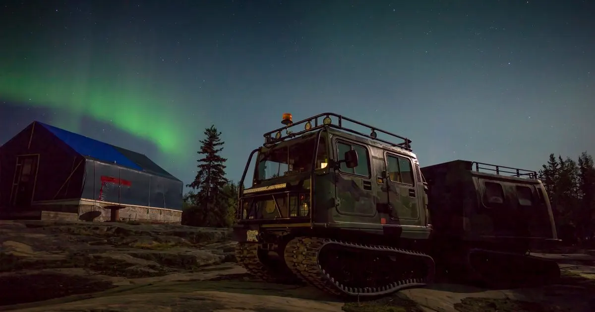 Car loans Northwest Territories: a tracked all-terrain vehicle under the aurora near Yellowknife