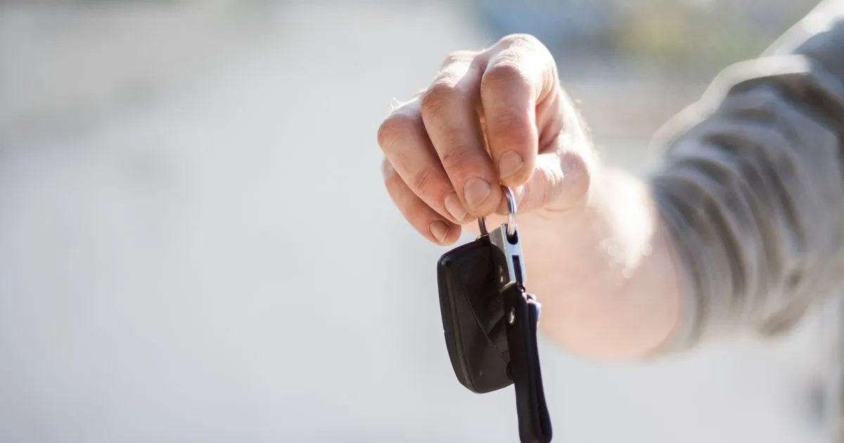 Handing over car keys after completing the sworn statement to gift a car in Ontario