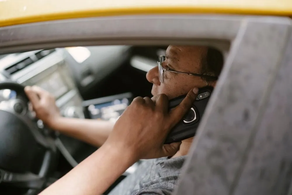 Newcomer confirming car loan details by phone from his vehicle