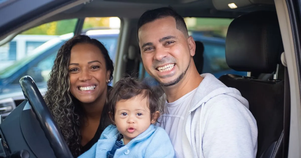 Newcomer car loans in Canada: young family smiling in their first vehicle