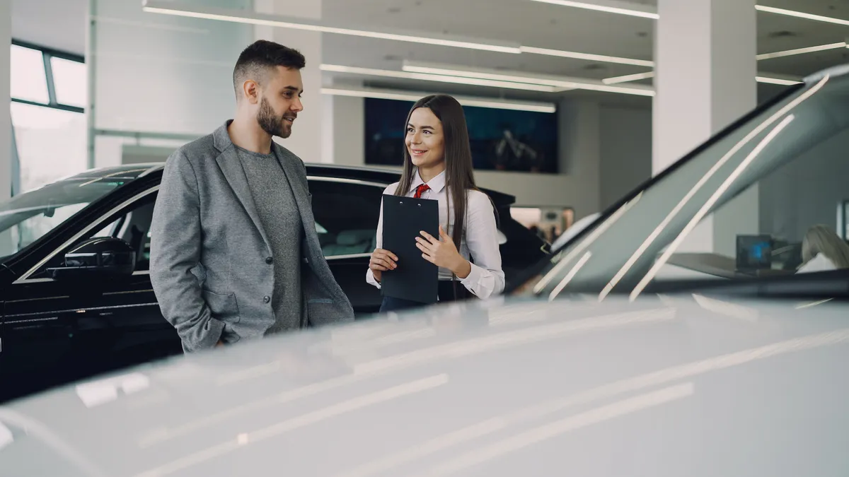 Bad credit car loans Canada: buyer comparing offers with a salesperson in a showroom